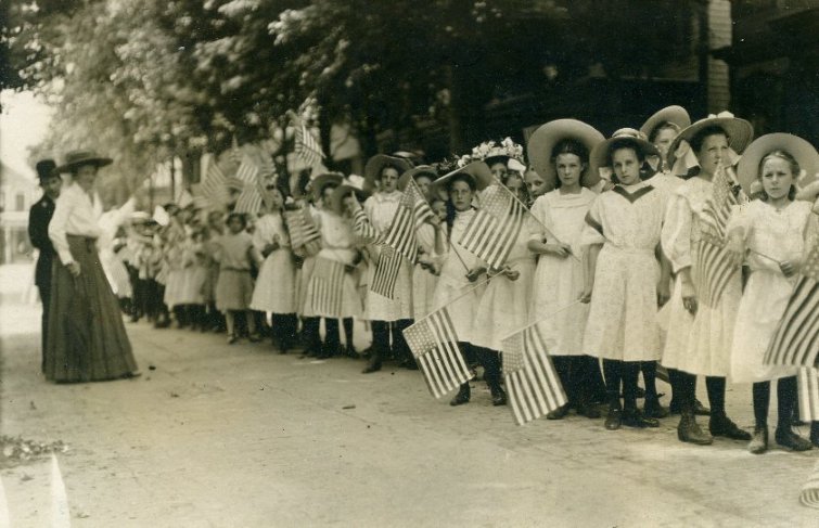 girls in white dresses with flags